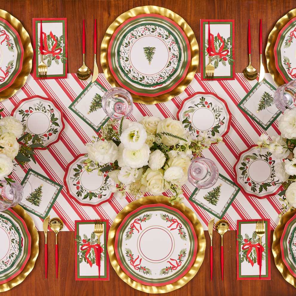 Set a festive Christmas table with gold chargers, red and white striped placemats, gold cutlery, red napkins, and elegant white floral centerpieces. For the perfect holiday touch, use Sophistiplate’s Home for the Holidays Dinner Plates (8 pack), featuring charming Christmas tree designs.