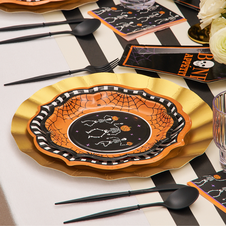 Haunt your table with Sophistiplate’s Haunted Halloween Paper Salad Plates (8pk)—gold and orange plates featuring dancing skeletons, paired with black cutlery, “Bone Appétit” black napkins in orange, and a striped runner; an enchanting addition from our Haunted Halloween Collection.