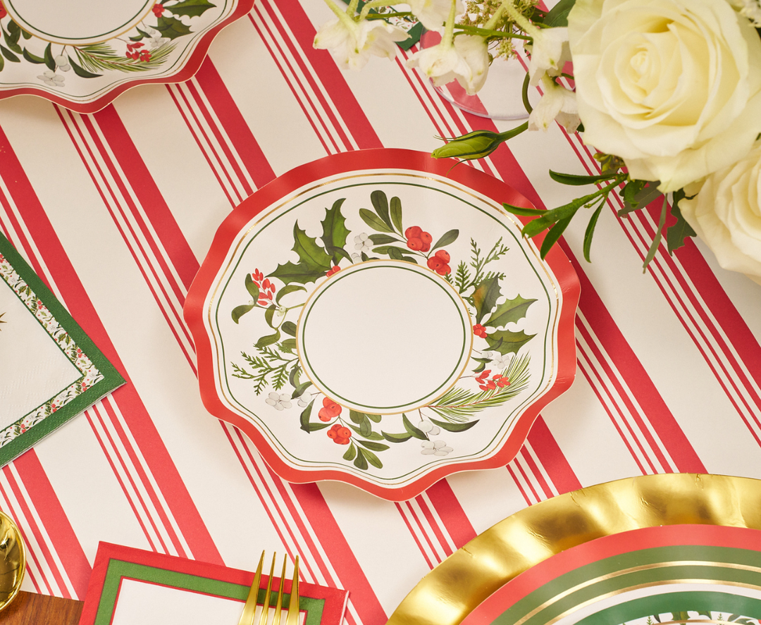 Create a festive holiday tablescape by pairing scalloped plates adorned with holly, pine, and berries on a red-striped tablecloth, surrounded by gold utensils and white blooms. For effortless entertaining, serve your favorite treats in the Sophistiplate Home for the Holidays Appetizer/Dessert Bowls (8pk)—these disposable bowls add a charming wavy-edge detail to your Christmas party or holiday gathering.