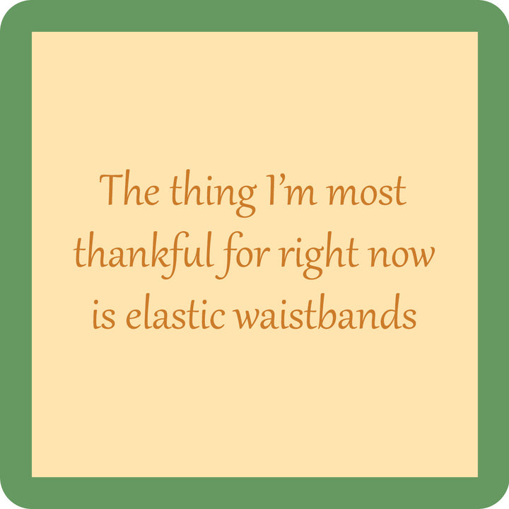 Drinks On Me’s Waistband Coaster features a beige square with a green border and the words “The thing I’m most thankful for right now is elastic waistbands” in a light brown font—ideal as a funny coaster or bar cart accent.