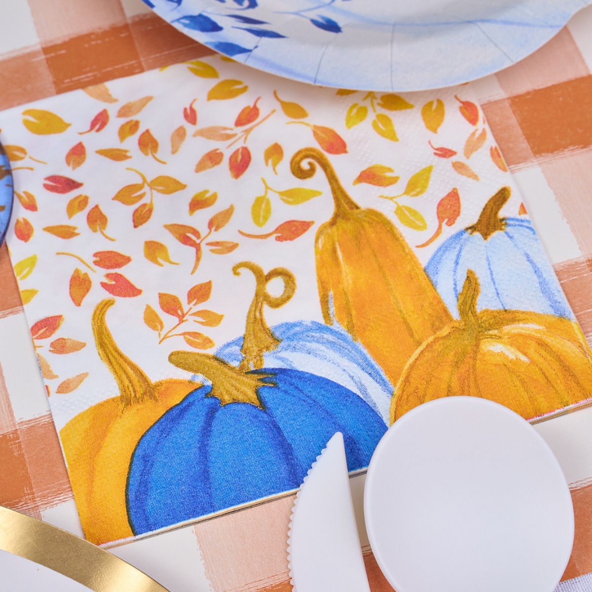 Add a charming touch to your holiday gatherings with Sophistiplate’s “Harvest Blues” Cocktail Napkins (26/pkg), featuring blue and orange pumpkins with falling leaves on a checkered tablecloth design—perfect for pairing seamlessly with other paper tableware.