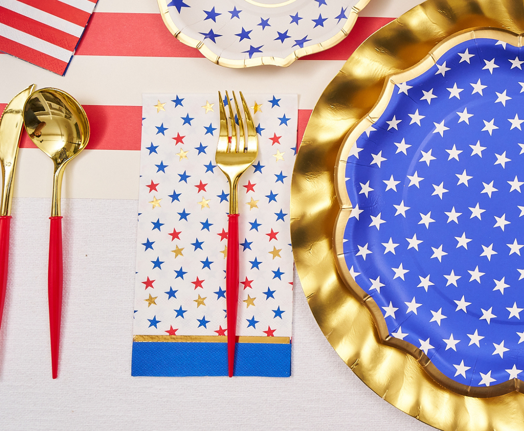 Create a festive July 4th table with Sophistiplate's Party in the USA Guest Towels (20pk), featuring colorful stars—perfect with gold utensils, blue and gold-edged plates for a vibrant patriotic celebration.