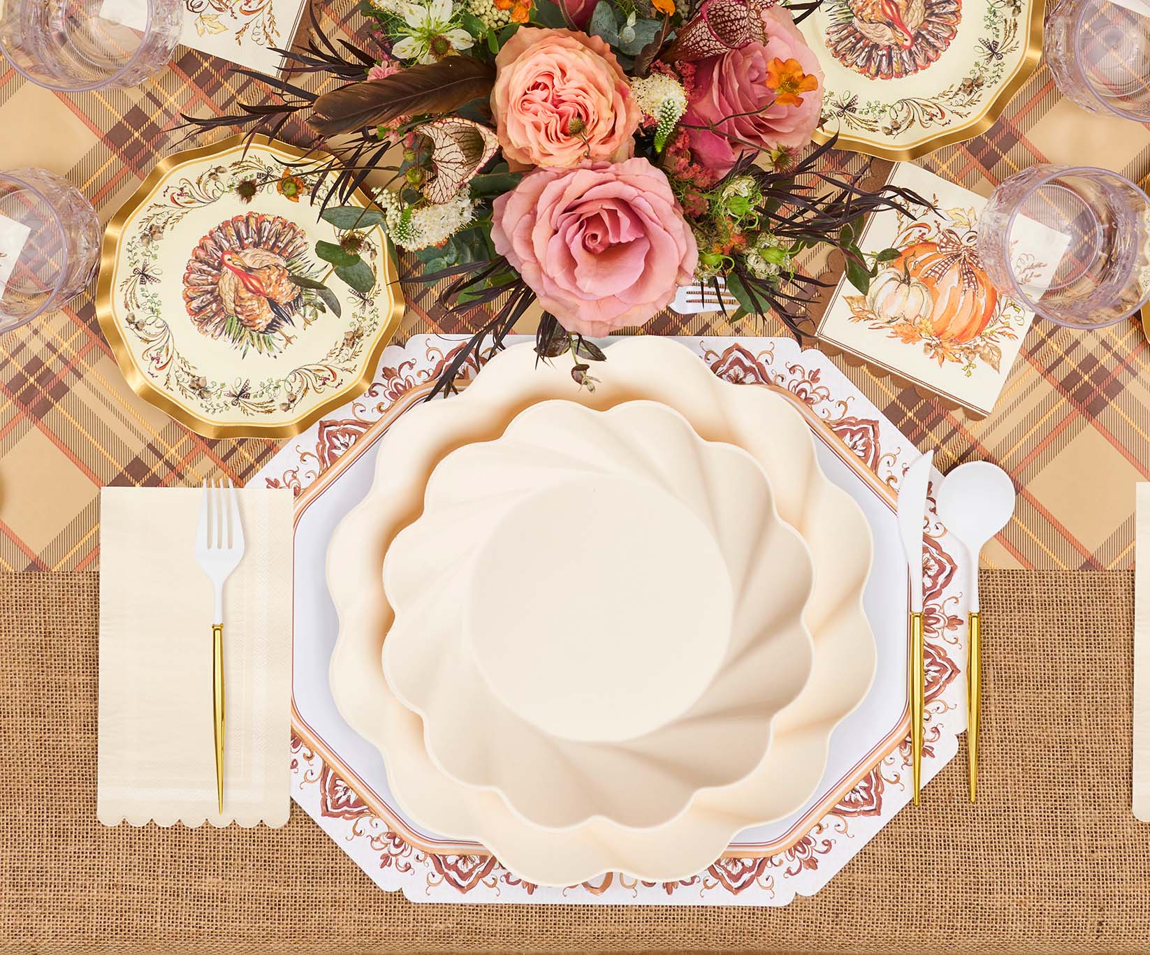 Create a festive Thanksgiving table with Ivory Harvest: Thanksgiving Table for 16 by Sophistiplate LLC, featuring scalloped plates, gold utensils, a plaid tablecloth, and chic autumn-inspired decor.