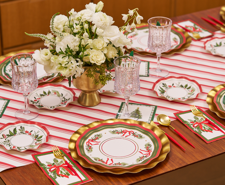 Celebrate in style with a festive table setting featuring Sophistiplate’s Home for the Holidays Dinner Plates (8-pack). These elegant Christmas plates add a touch of gold, red, and green to your table alongside crystal glasses and shimmering gold flatware. A white floral arrangement rests at the center atop a red and white striped runner, complemented by holiday cards and napkins for a complete holiday look.
