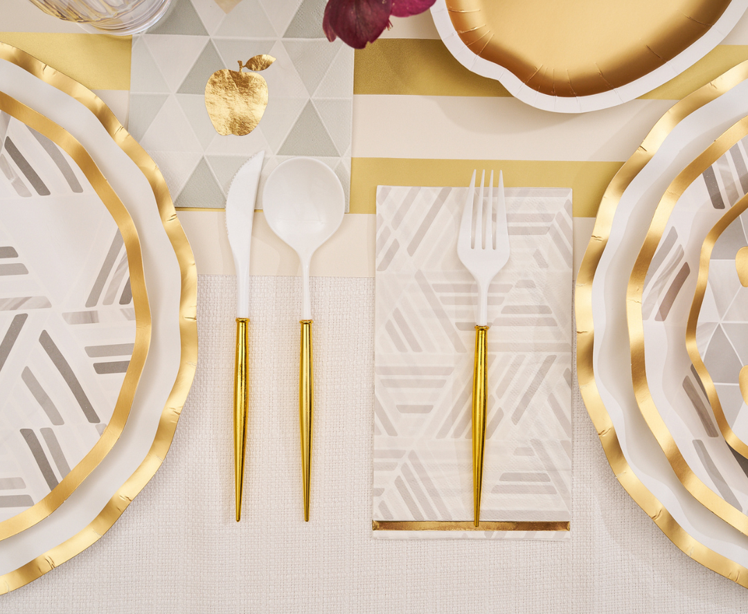 For a festive Rosh Hashanah celebration, the Sophistiplate Golden Apple Table Setting creates an elegant tablescape with gold-edged disposable plates, white and gold cutlery, and a folded napkin featuring geometric patterns atop a gold-striped tablecloth. Each placemat displays a golden apple design for a truly celebratory touch.