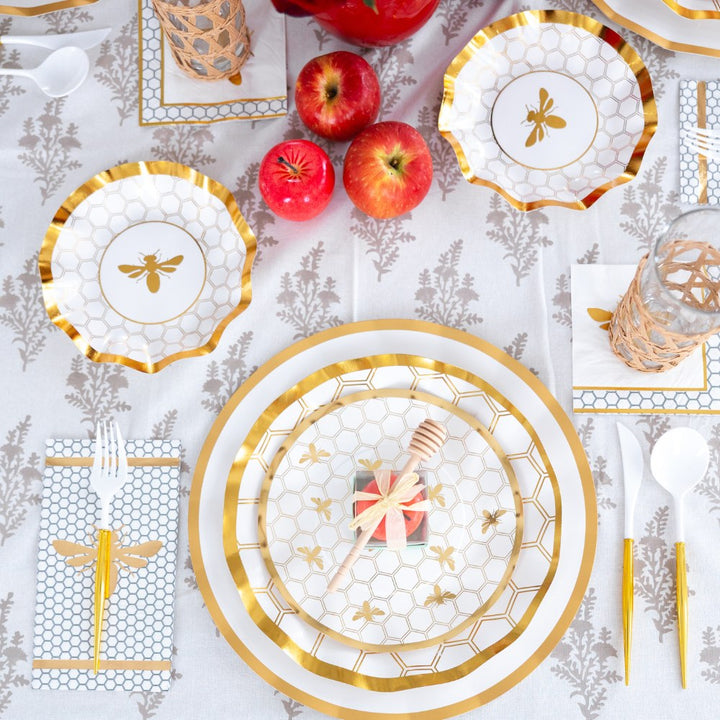 Create an elegant and festive Rosh Hashanah table setting with the Sophistiplate LLC Rosh Tablescape for 16 Guests: White Honeybee. This bee-themed set features gold and white designer disposable plates, gold utensils, apples, a honey dipper gift, and a patterned tablecloth for a beautiful holiday celebration.