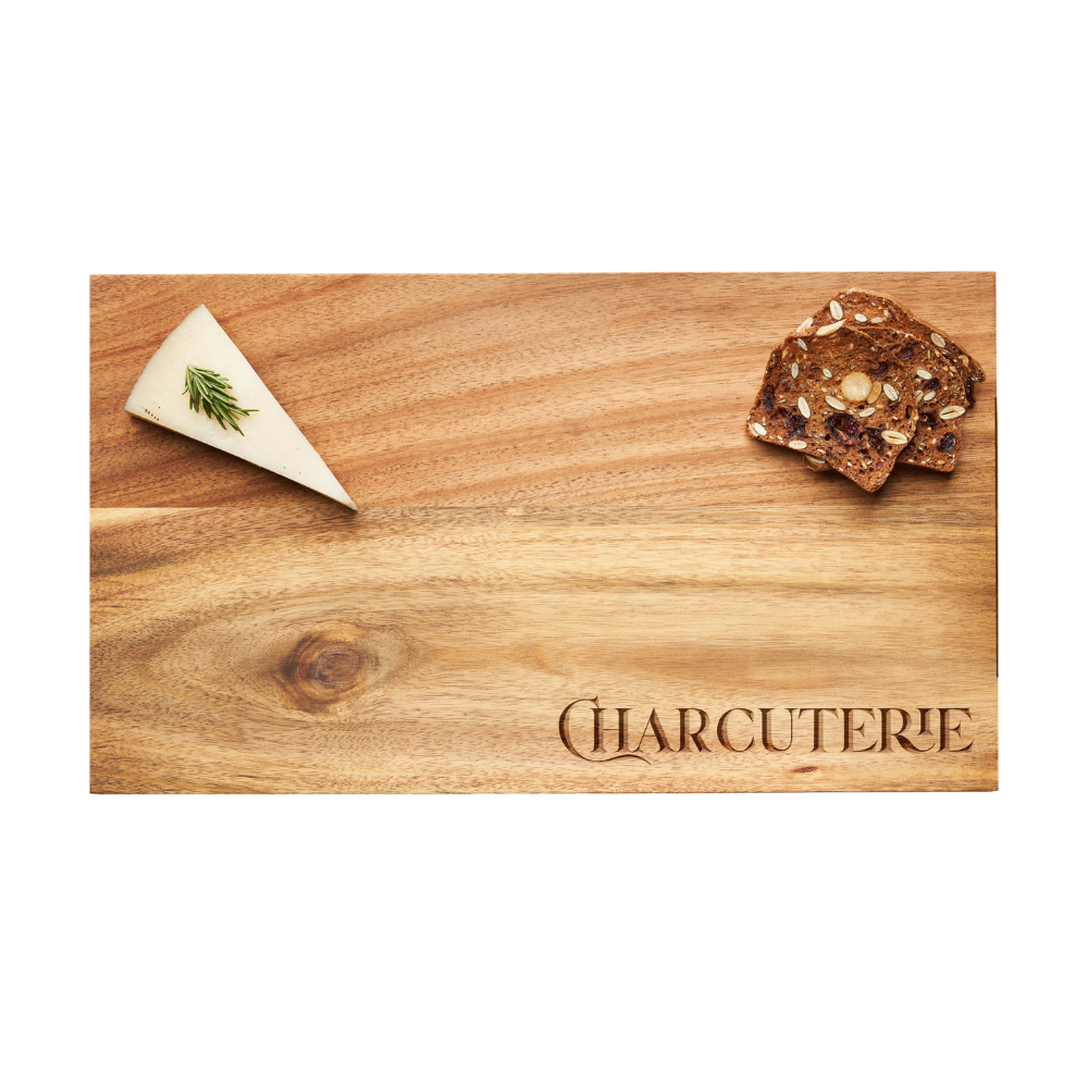 A slice of cheese garnished with herbs and a stack of seeded crackers are served on the Maple Modern Acacia Rectangle | Parisian Charcuterie 14 x 8″ board, elegantly engraved with “CHARCUTERIE” on its acacia wood surface.