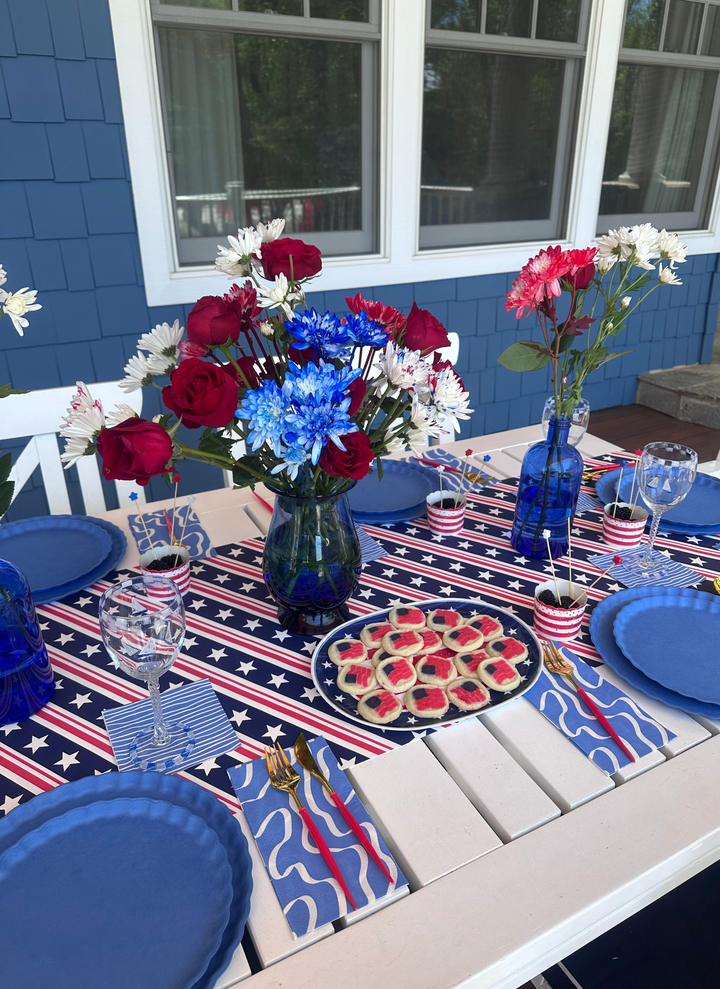 Celebrate in style with Sophistiplate LLC’s 4th of July Table for 16+ in French Blue—featuring eco-friendly disposable plates, gold cutlery, and patriotic accents perfect for a festive outdoor gathering.