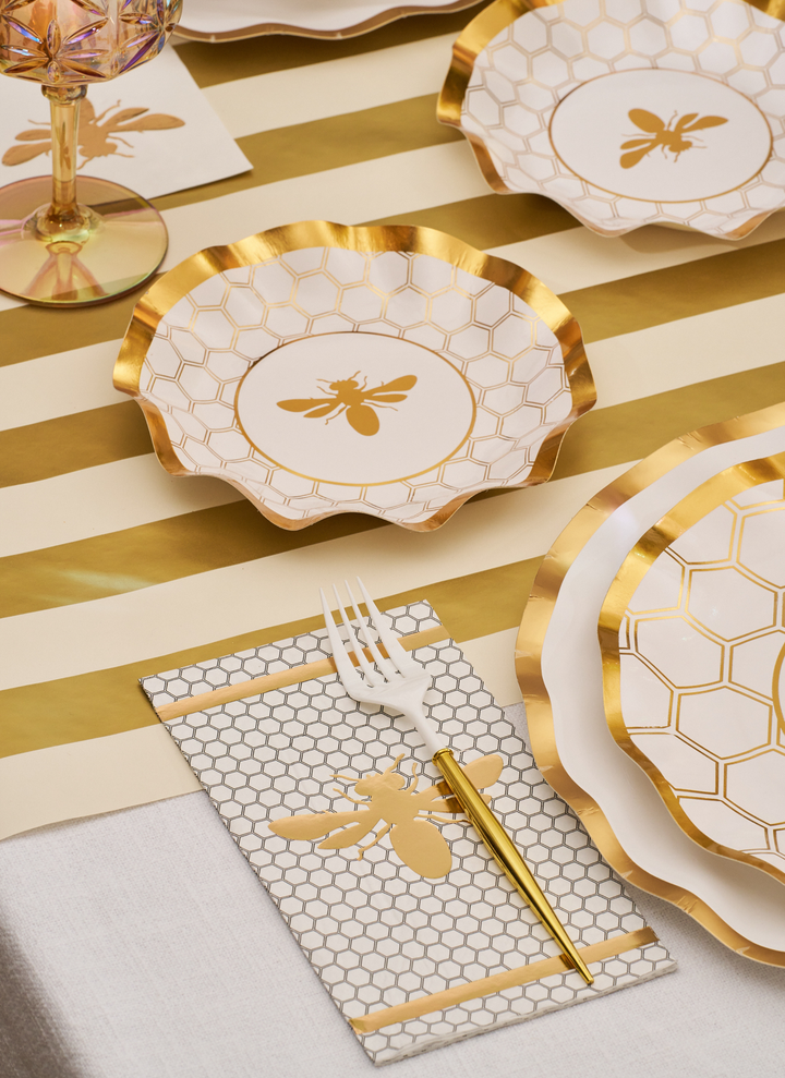 Create a cohesive bee-themed decor with the White Honeybee Table Setting from Sophistiplate, featuring gold-rimmed disposable plates adorned with charming bee and honeycomb designs. Paired with a gold-striped tablecloth, a gold fork, and a glass rimmed in gold, this elegant set blends style and convenience for your next celebration.