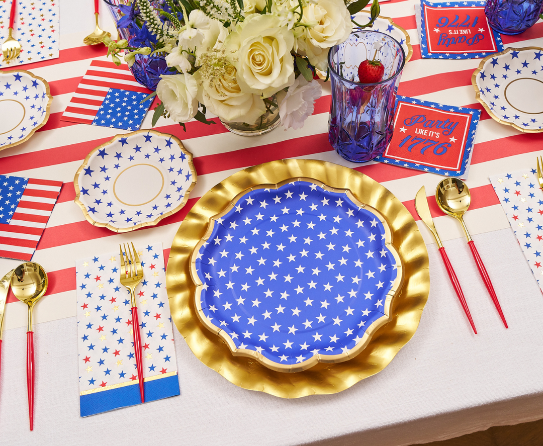 Create a festive July 4th table with Sophistiplate’s Party in the USA Dinner Plates (8pk), gold chargers, red and gold cutlery, American flag napkins, patriotic flowers, and themed cards—perfect for your Independence Day celebration.