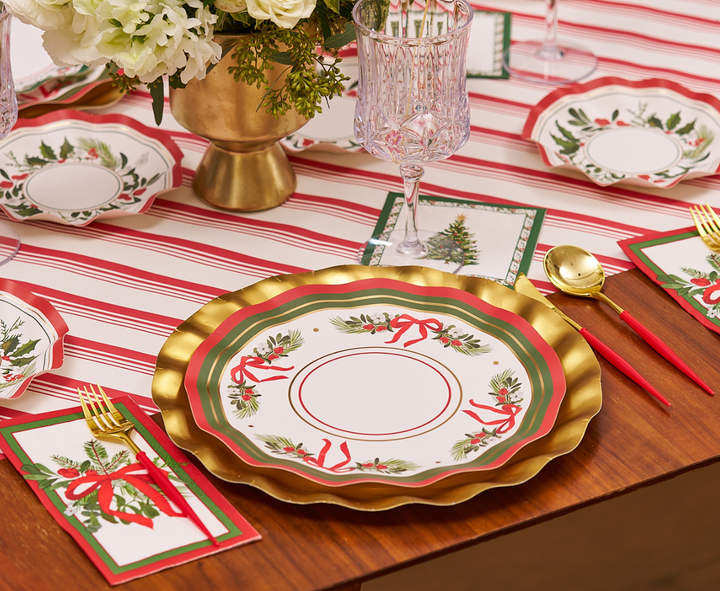 Create a festive table setting with Sophistiplate’s Home for the Holidays Dinner Plates (8pk), featuring elegant gold, red, and green designs adorned with holiday wreaths and ribbons. Pair these plates with crystal glasses, gold cutlery, and Christmas-themed napkins on a red-striped tablecloth—the perfect way to add extra cheer to your holiday celebration.