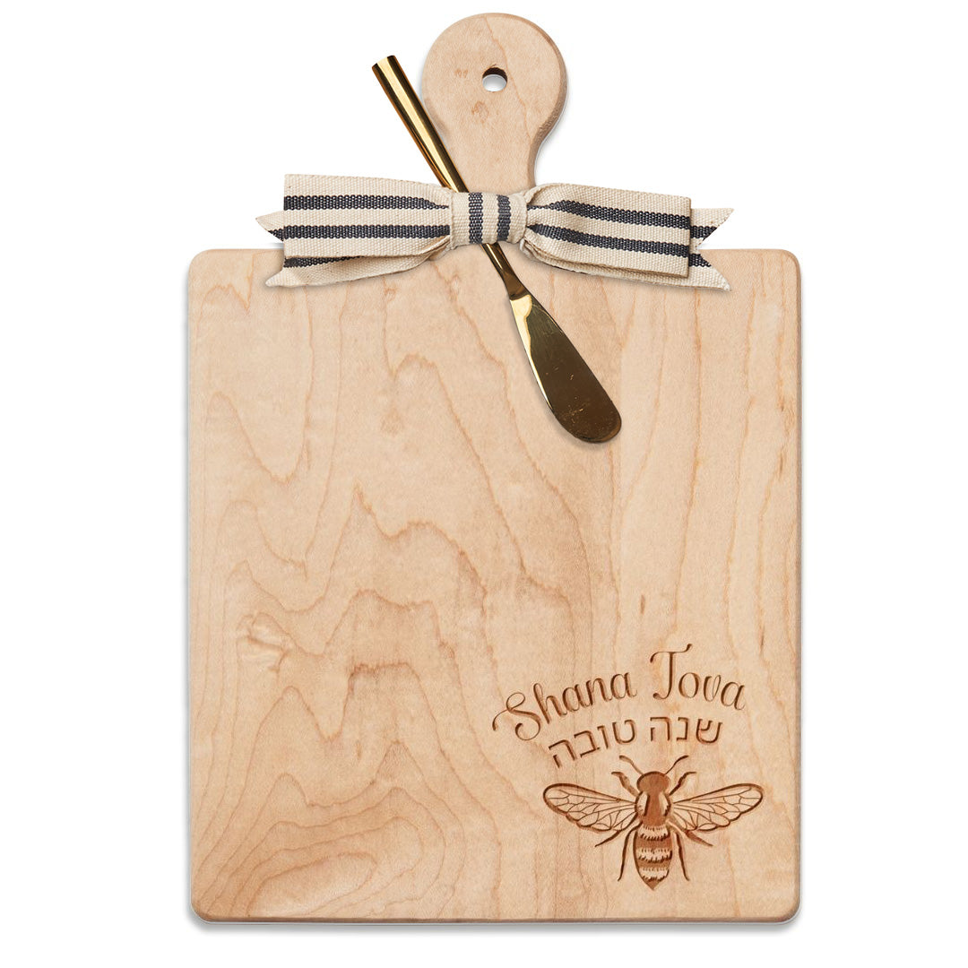 Celebrate the holidays with the Maple 9″x6″ Maple Wood Board with Gold Spreader, featuring “Shana Tova” elegantly engraved in English and Hebrew above a graceful bee design. Adorned with a striped ribbon and paired with a gold-colored spreader, this beautiful board from Maple is perfect for serving cheese or charcuterie and enhancing your festive gatherings.