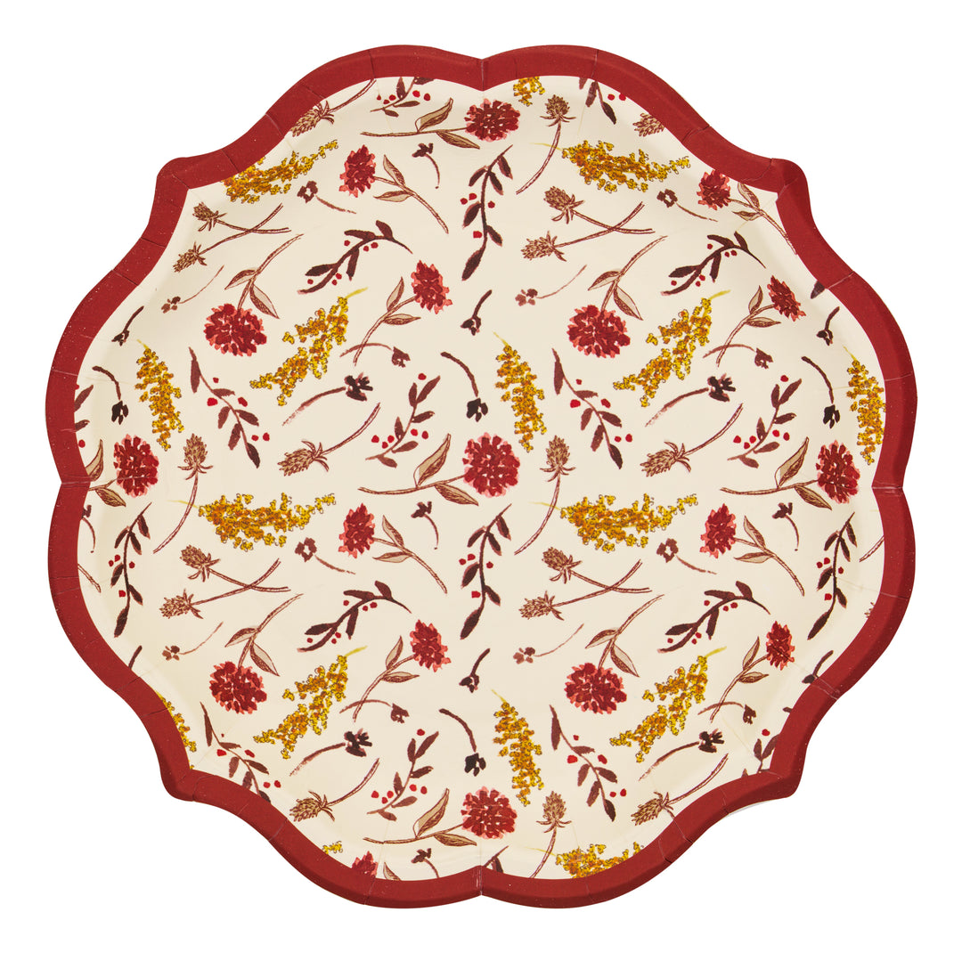 Sophistiplate’s Amber Harvest Salad Plates (8pk) feature a scalloped edge with a red border and a charming floral pattern of red and yellow flowers with brown stems and leaves on a cream background—making these elegant disposable plates the perfect addition to your Thanksgiving table.