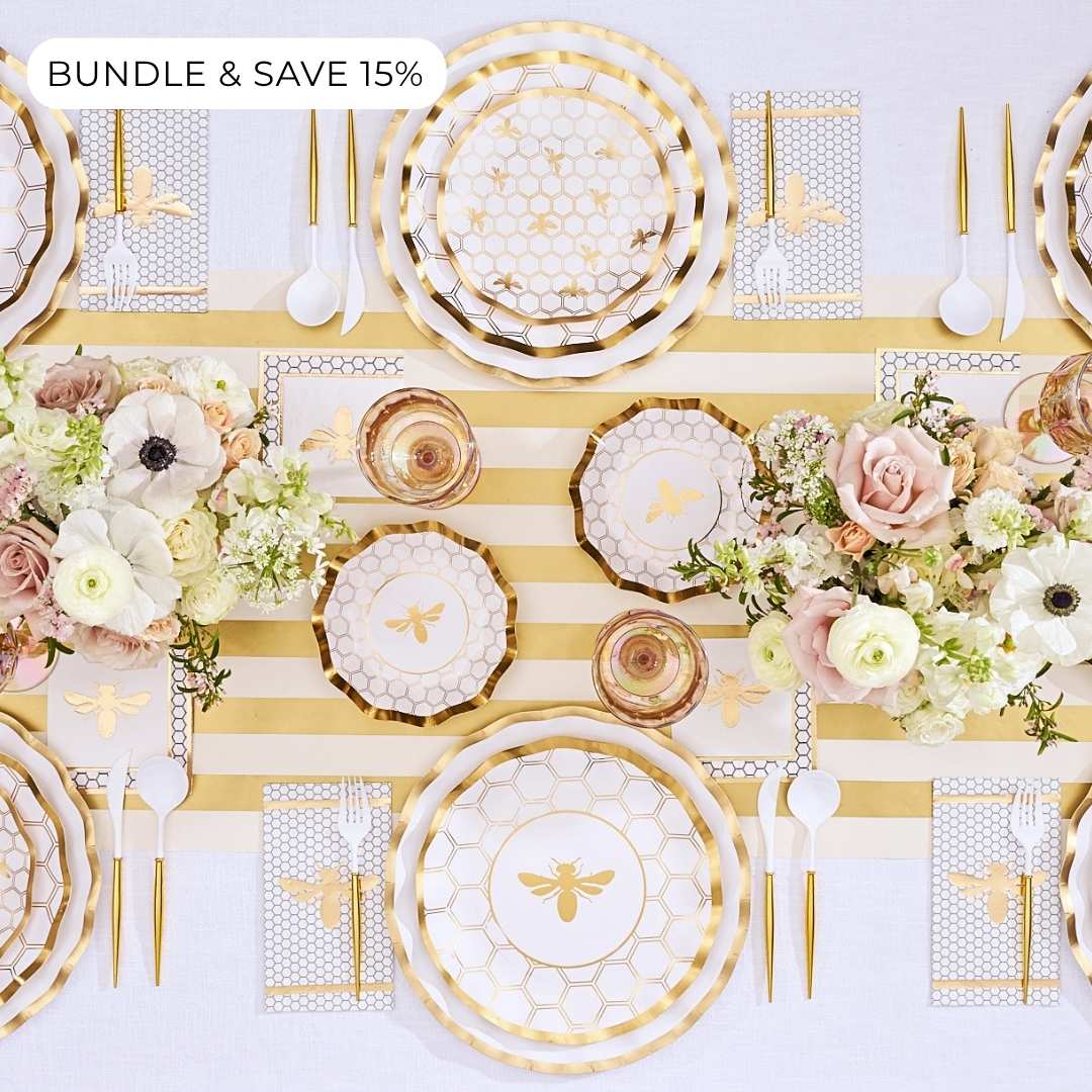 Bundle & Save 15% (label in upper left corner) Create a stylish Rosh Hashanah table setting with the “Rosh Tablescape for 16 Guests: White Honeybee” by Sophistiplate LLC, featuring elegant gold honeybee-themed designer disposable plates, coordinating gold utensils, floral centerpieces, and a chic gold-and-white striped table runner.