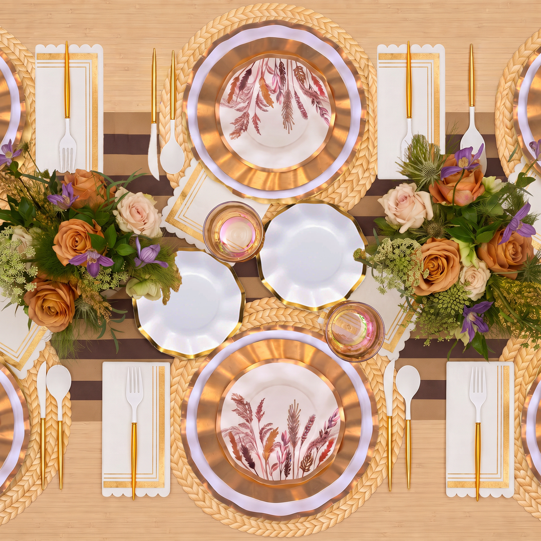Tabletop view of the Harvest Gold Table Setting by Sophistiplate, featuring elegant floral arrangements, gold-accented decorative paper plates, cutlery, glasses, and napkins neatly arranged on a striped runner.