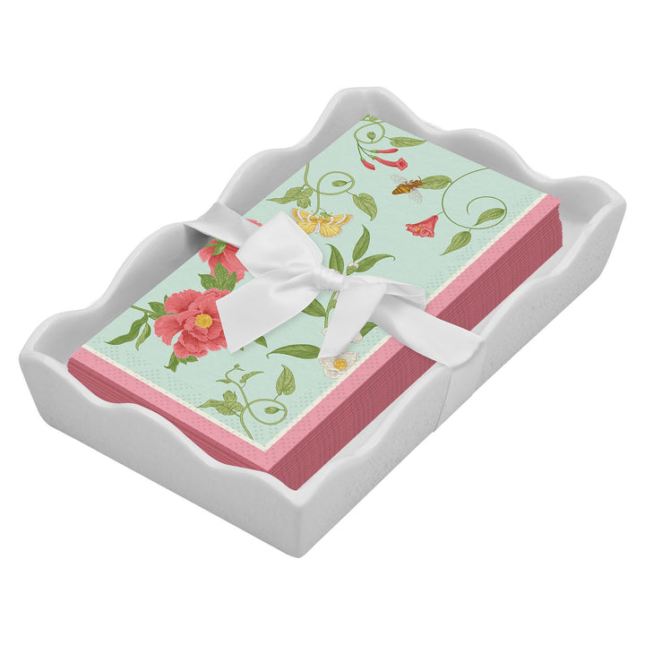 The Sophistiplate Floral Guest Towel with Napkin Tray features floral-patterned napkins with pink edges, tied with a white ribbon and elegantly displayed in a scalloped ceramic tray.