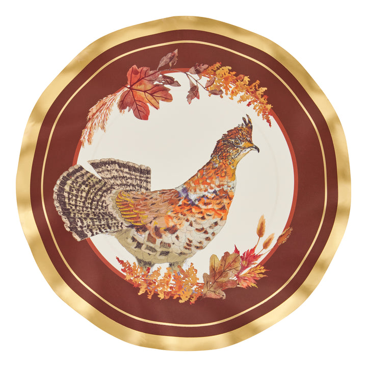 A decorative plate with a gold rim features an illustrated grouse surrounded by autumn leaves on a burgundy background, reminiscent of the elegant Sophistiplate Woodland Harvest Salad Plates (8pk)—perfect for elevating your Thanksgiving table alongside turkey paper plates and other Thanksgiving disposable plates.