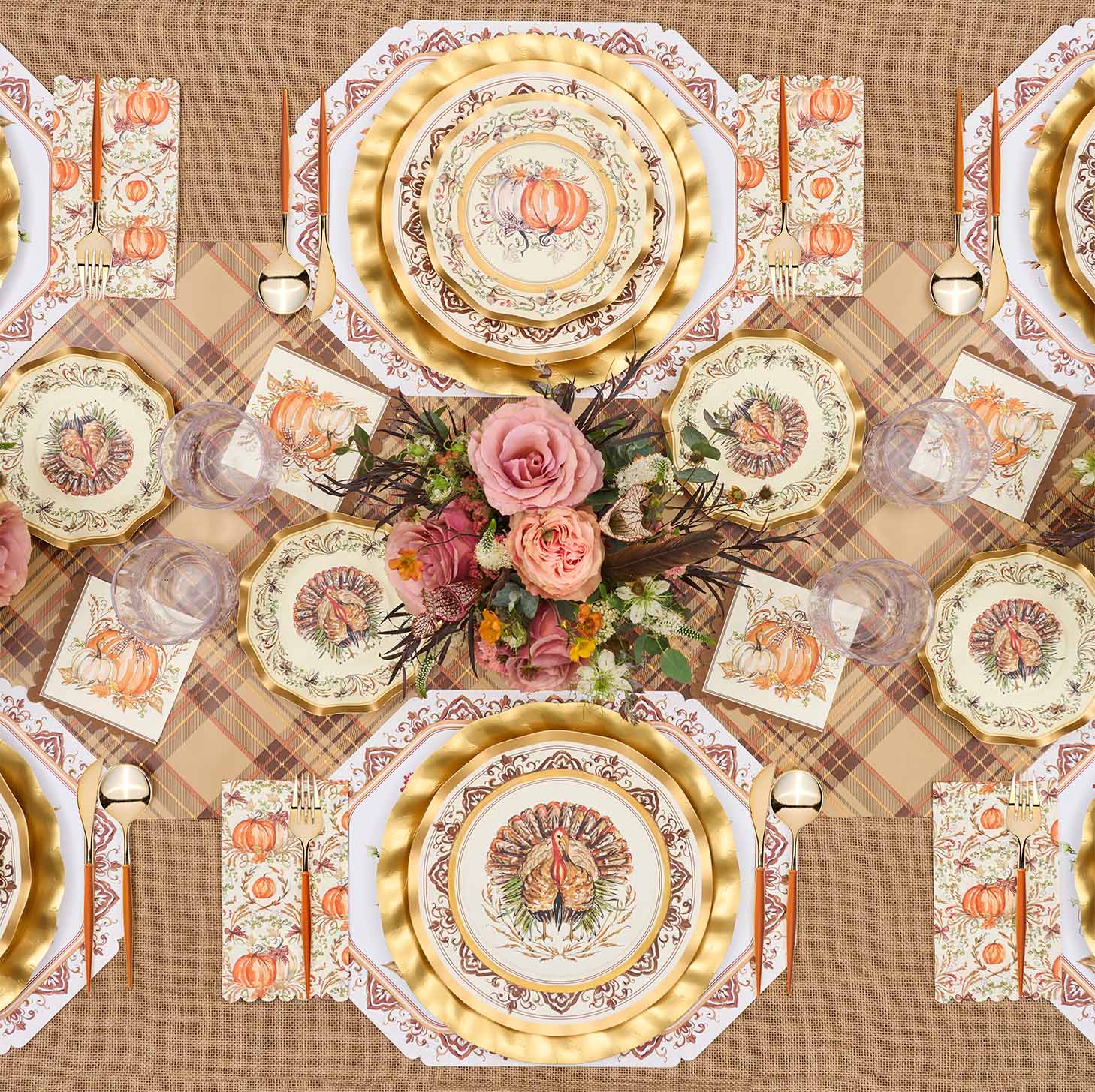 Create a festive autumn table with the Turkey & Gourds Table Setting Bundle from Sophistiplate LLC, featuring designer disposable plates adorned with turkeys and pumpkins, gold chargers, a floral centerpiece of pink roses, a plaid tablecloth, coordinated gold utensils, and glasses—all beautifully arranged for your seasonal celebration.