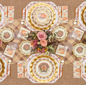 The Turkey & Gourds Table Setting by Sophistiplate LLC features designer disposable plates with turkey and pumpkin motifs, gold cutlery, pink rose floral centerpiece, plaid placemats, autumn napkins, and a burlap tablecloth.